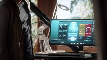Movie still from “Salvation” (2017), created by Elizabeth Kruger – A computer monitor sitting on top of a desk; Medium shot, Over the shoulder angle