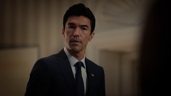 Movie still from “Salvation” (2017), created by Elizabeth Kruger – A person wearing a suit and tie; Close Up shot, Low angle