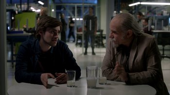 Movie still from “Salvation” (2017), created by Elizabeth Kruger – Two men are sitting at a table talking to each other; Medium shot, Over the shoulder angle