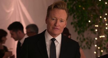 Movie still from “Sandy Wexler” (2017), directed by Steven Brill – A person wearing a suit and tie; Close Up shot, Over the shoulder angle