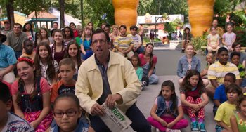 Movie still from “Sandy Wexler” (2017), directed by Steven Brill – A group of people sitting on the ground with bags of food; Wide shot, Over the shoulder angle