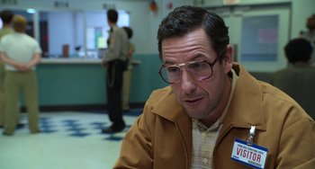 Movie still from “Sandy Wexler” (2017), directed by Steven Brill – A man with glasses is sitting in a room; Close Up shot, Over the shoulder angle