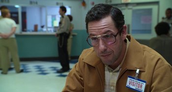 Movie still from “Sandy Wexler” (2017), directed by Steven Brill – A man with glasses sitting in front of a counter; Close Up shot, Over the shoulder angle