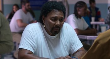 Movie still from “Sandy Wexler” (2017), directed by Steven Brill – A man with a beard is sitting at a table; Close Up shot, Over the shoulder angle