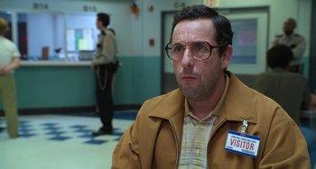 Movie still from “Sandy Wexler” (2017), directed by Steven Brill – A man in a brown jacket and glasses is in a room; Close Up shot, Over the shoulder angle