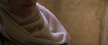 Movie still from “Secrets of the Saqqara Tomb” (2020), directed by James Tovell – A person is wearing a white scarf and smiling; Extreme Close Up shot, Over the shoulder angle