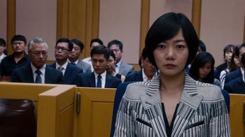 Movie still from “Sense8” (2015), directed by Tom Tykwer – A woman standing in front of a group of people; Close Up shot, Over the shoulder angle