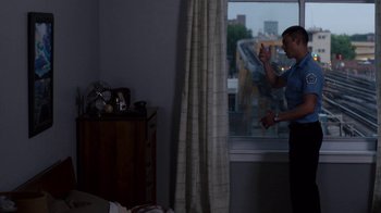 Movie still from “Sense8” (2015), directed by Tom Tykwer – A man standing next to a window in a room; Wide shot, Over the shoulder angle