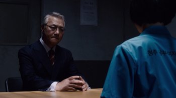 Movie still from “Sense8” (2015), directed by Tom Tykwer – A man sitting at a table in front of another man; Medium shot, Over the shoulder angle