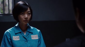 Movie still from “Sense8” (2015), directed by Tom Tykwer – A woman in a blue shirt with a number on it; Close Up shot, Over the shoulder angle