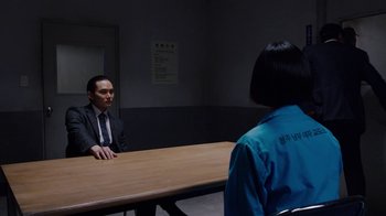Movie still from “Sense8” (2015), directed by Tom Tykwer – A man and a woman sitting at a wooden table; Medium shot, Over the shoulder angle