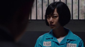 Movie still from “Sense8” (2015), directed by Tom Tykwer – A woman in a blue prison uniform looking at the camera; Close Up shot, Over the shoulder angle