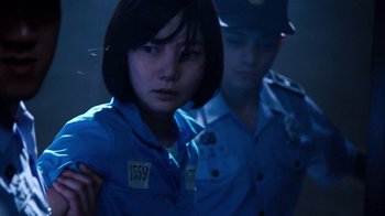 Movie still from “Sense8” (2015), directed by Tom Tykwer – A woman in a blue shirt is standing next to a man in a blue uniform; Close Up shot, Over the shoulder angle