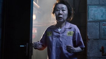 Movie still from “Sense8” (2015), directed by Tom Tykwer – An asian woman in a purple shirt with numbers on it; Medium shot, High angle