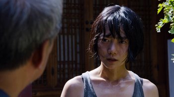 Movie still from “Sense8” (2015), directed by Tom Tykwer – A young woman with black hair looking at the camera; Close Up shot, Over the shoulder angle