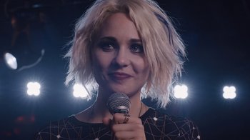 Movie still from “Sense8” (2015), directed by Tom Tykwer – A woman holding a microphone in front of a crowd; Close Up shot, Over the shoulder angle