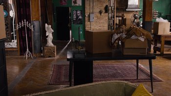 Movie still from “Sense8” (2015), directed by Tom Tykwer – A living room filled with furniture next to a brick wall; Wide shot, High angle