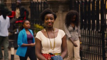 Movie still from “Sense8” (2015), directed by Tom Tykwer – A young woman standing in front of other young women; Medium shot, Over the shoulder angle