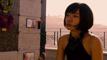 Movie still from “Sense8” (2015), directed by Tom Tykwer – A woman standing in front of a stone wall; Close Up shot, Over the shoulder angle