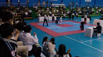 Movie still from “Sense8” (2015), directed by Tom Tykwer – A group of people sitting in a gym watching an event; Extreme Wide shot, High angle