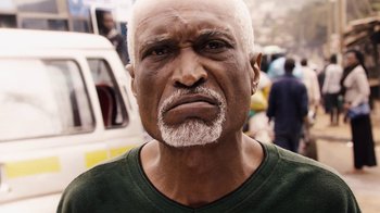Movie still from “Sense8” (2015), directed by Tom Tykwer – An older man with a white beard is looking at the camera; Close Up shot, Low angle