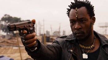 Movie still from “Sense8” (2015), directed by Tom Tykwer – A man in a leather jacket holding a gun; Close Up shot, Low angle