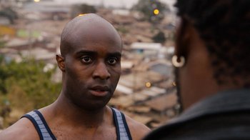 Movie still from “Sense8” (2015), directed by Tom Tykwer – A man with a bald head talking to another man; Close Up shot, Over the shoulder angle