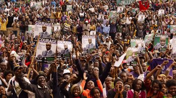 Movie still from “Sense8” (2015), directed by Tom Tykwer – A large crowd of people are gathered in a stadium; Extreme Wide shot, High angle