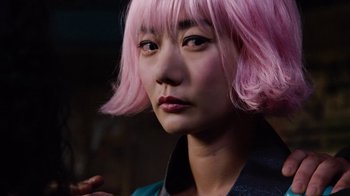 Movie still from “Sense8” (2015), directed by Tom Tykwer – A person wearing a pink wig; Close Up shot, Low angle