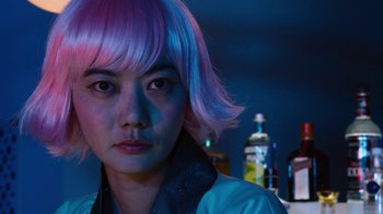 Movie still from “Sense8” (2015), directed by Tom Tykwer – A woman with pink hair is looking at the camera; Close Up shot, Over the shoulder angle