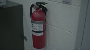 Movie still from “Mr. Robot” (2015), created by Sam Esmail – A fire extinguisher hanging on the wall of a building; Extreme Close Up shot, High angle