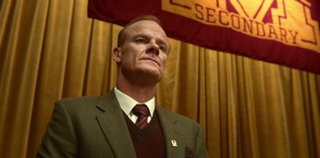 Movie still from “Sex Education” (2019), created by Laurie Nunn – A man in a suit and a tie; Close Up shot, Low angle