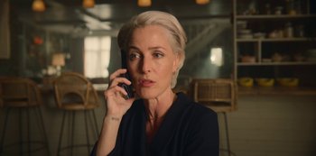 Movie still from “Sex Education” (2019), created by Laurie Nunn – A woman talking on a cell phone while sitting in a chair; Close Up shot, Over the shoulder angle