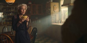 Movie still from “Sex Education” (2019), created by Laurie Nunn – A woman sitting in a kitchen holding a coffee cup; Medium shot, Over the shoulder angle
