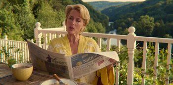 Movie still from “Sex Education” (2019), created by Laurie Nunn – A woman sitting at a table reading a newspaper; Medium shot, Over the shoulder angle