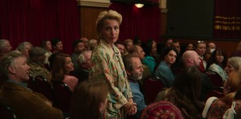 Movie still from “Sex Education” (2019), created by Laurie Nunn – A woman standing in front of an audience in a theater; Medium shot, Over the shoulder angle