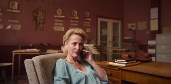 Movie still from “Sex Education” (2019), created by Laurie Nunn – A woman sitting in a chair talking on a phone; Medium shot, Over the shoulder angle