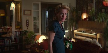 Movie still from “Sex Education” (2019), created by Laurie Nunn – A woman holding a bottle of wine in her hand; Medium shot, Low angle