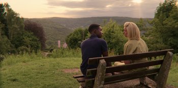 Movie still from “Sex Education” (2019), created by Laurie Nunn – A man and a woman sitting on a wooden bench; Medium shot, Over the shoulder angle