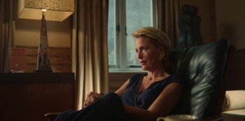 Movie still from “Sex Education” (2019), created by Laurie Nunn – A woman sitting in a chair in front of a window; Medium shot, Over the shoulder angle