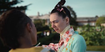 Movie still from “Sex Education” (2019), created by Laurie Nunn – A person with a weird hair style is talking to another person; Close Up shot, Over the shoulder angle