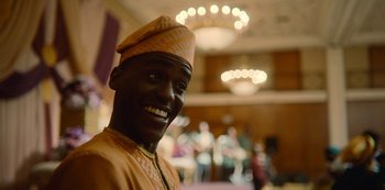 Movie still from “Sex Education” (2019), created by Laurie Nunn – A man wearing a turban smiles for the camera; Close Up shot, Over the shoulder angle