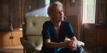 Movie still from “Sex Education” (2019), created by Laurie Nunn – A woman sitting on a couch in a living room; Medium shot, Over the shoulder angle