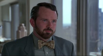 Movie still from “Sleepless in Seattle” (1993), directed by Nora Ephron – A person wearing a suit and a bow tie; Close Up shot, Over the shoulder angle