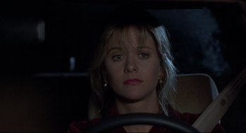 Movie still from “Sleepless in Seattle” (1993), directed by Nora Ephron – A woman sitting in the drivers seat of a car; Close Up shot, Over the shoulder angle
