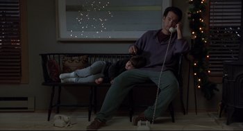 Movie still from “Sleepless in Seattle” (1993), directed by Nora Ephron – A man sitting on top of a wooden bench next to a child; Medium shot, High angle