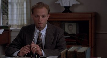 Movie still from “Sleepless in Seattle” (1993), directed by Nora Ephron – A man in a suit and tie sitting at a table; Close Up shot, High angle