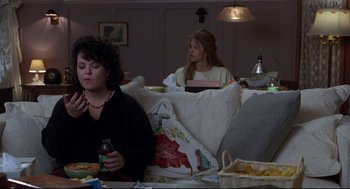 Movie still from “Sleepless in Seattle” (1993), directed by Nora Ephron – Two women are sitting in a living room eating; Medium shot, High angle