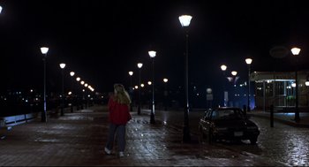 Movie still from “Sleepless in Seattle” (1993), directed by Nora Ephron – A woman in a red jacket standing on a sidewalk at night; Wide shot, Low angle