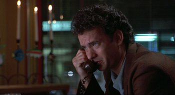 Movie still from “Sleepless in Seattle” (1993), directed by Nora Ephron – A man talking on a phone while sitting in a room; Close Up shot, Low angle